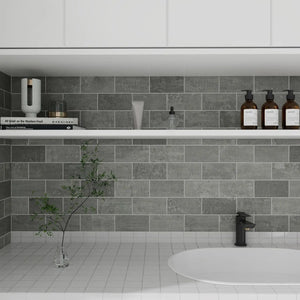 Modern bathroom with peel and stick gray tiled wall, white sink, and decorative elements.